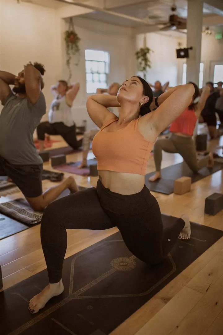 Students flowing through a breath-led Vinyasa class in the studio